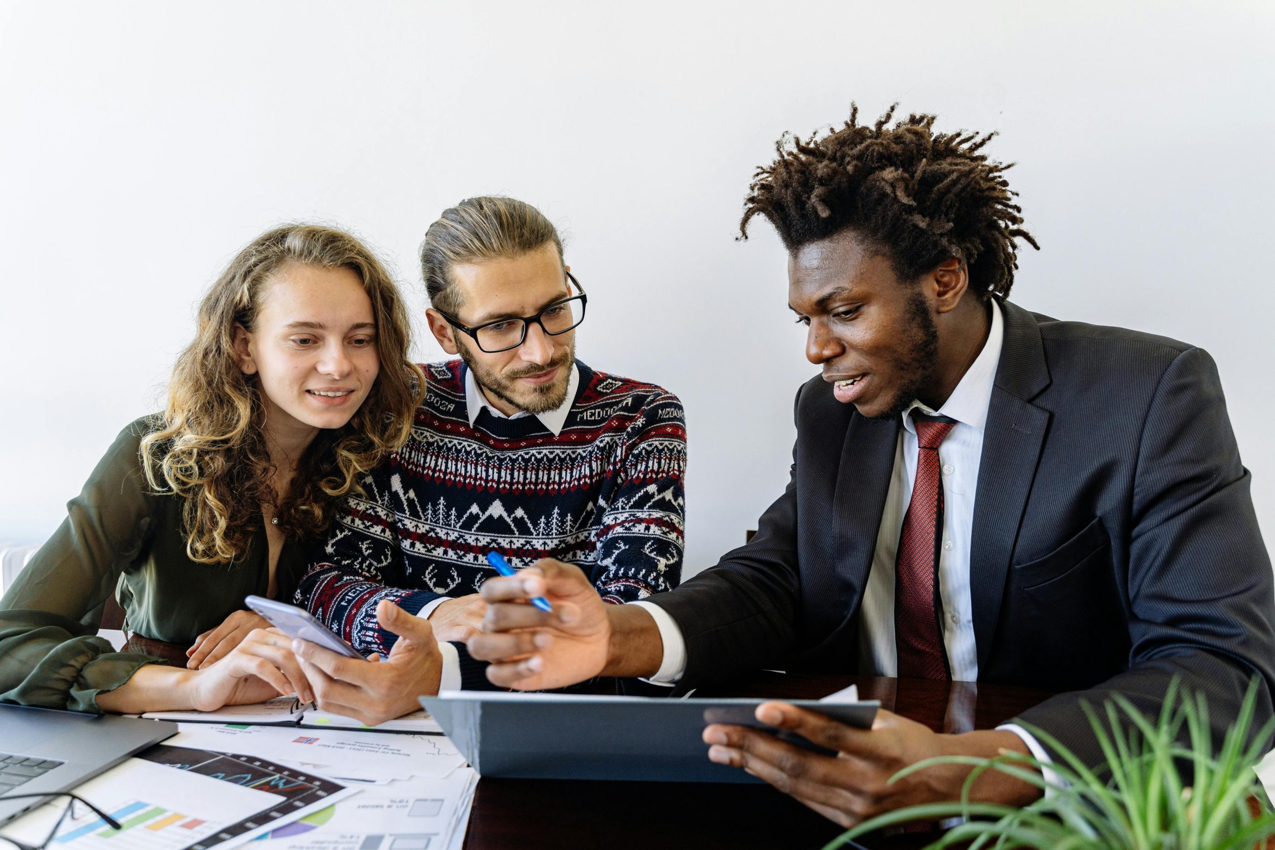 Offering Three professionals engaging in a collaborative business meeting in a modern office environment.